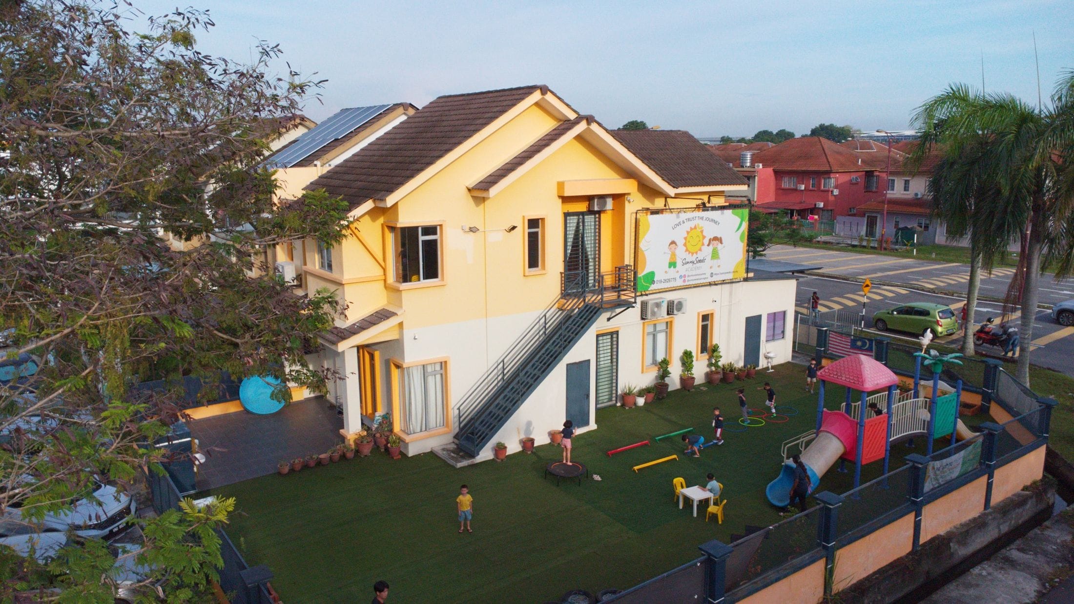 Aerial view of the SunnySeeds Academy school house and garden playground in Aman Perdana