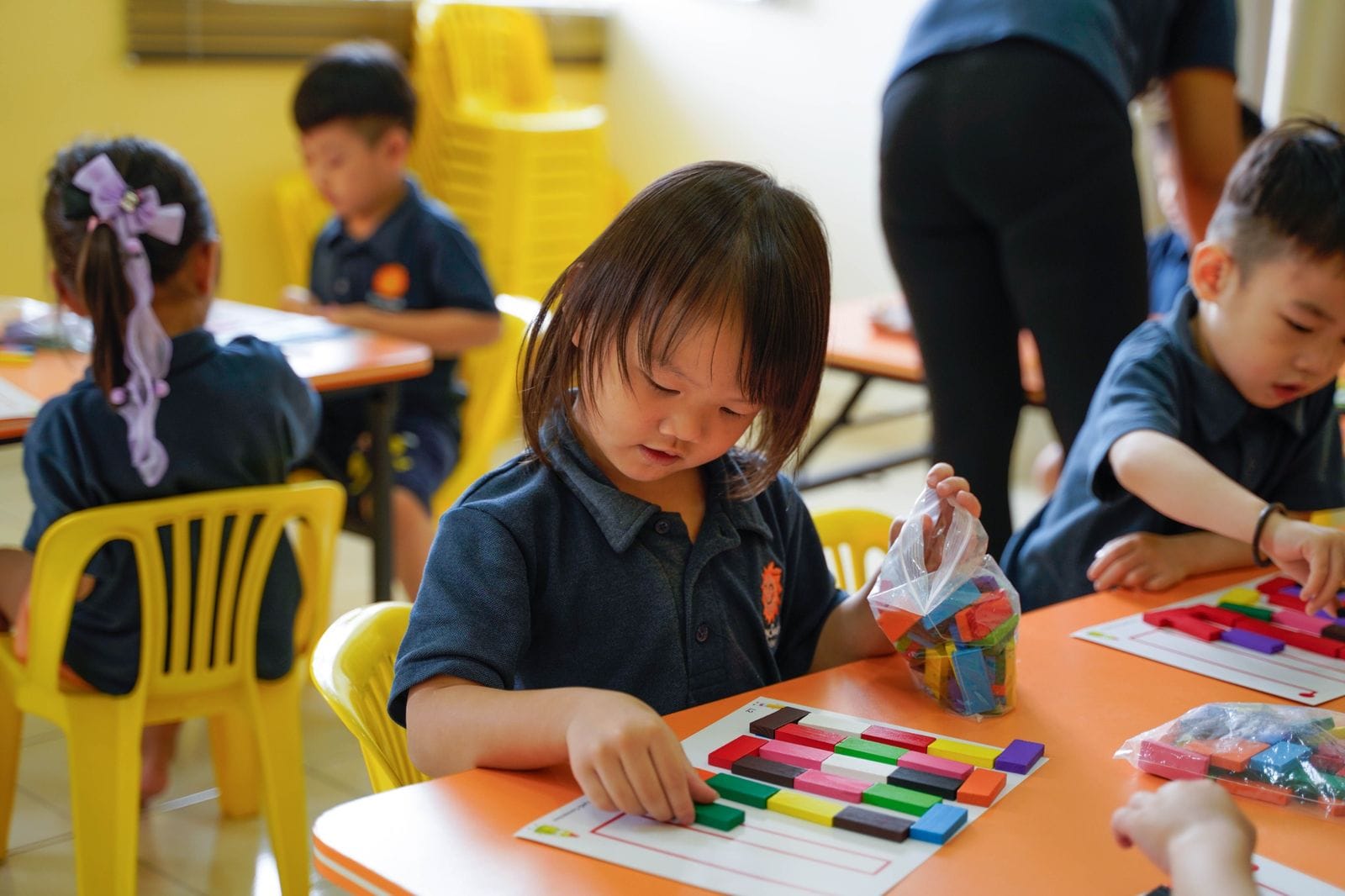 A preschool child sorting coloured number rods